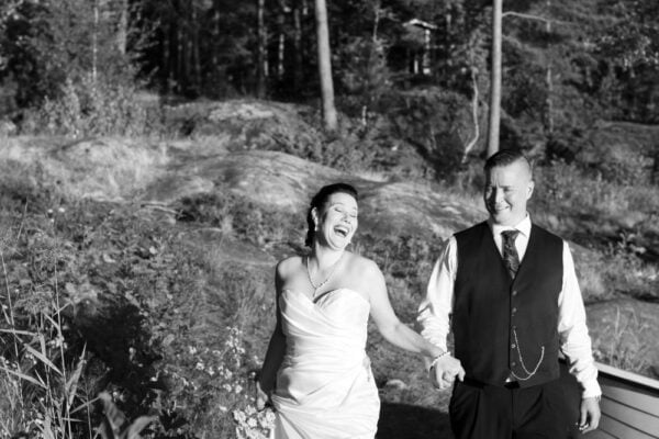 Black and white image of a wedding couple, with the bride laughing ecstatically.