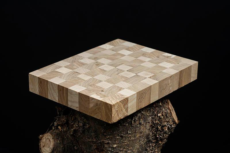 Product photography of a handcrafted cutting board with a black background.